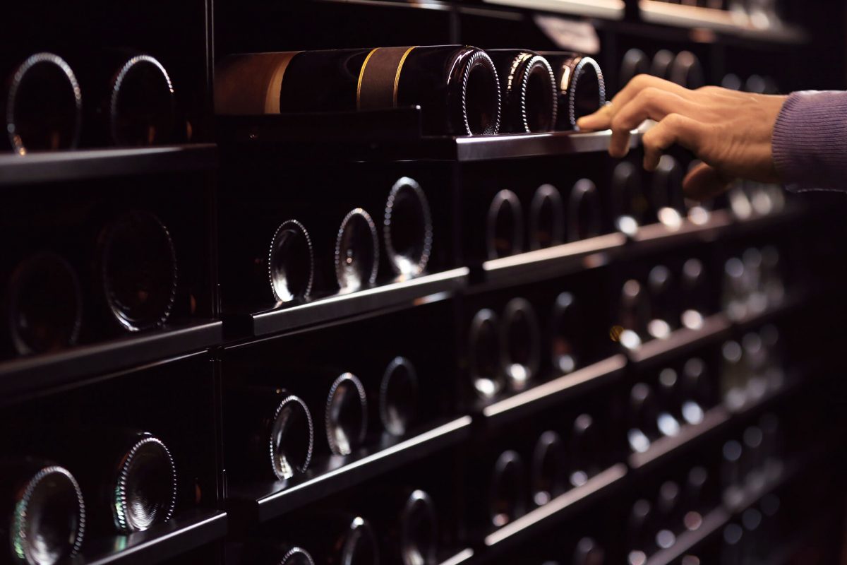 a person touching a bottle of wine
